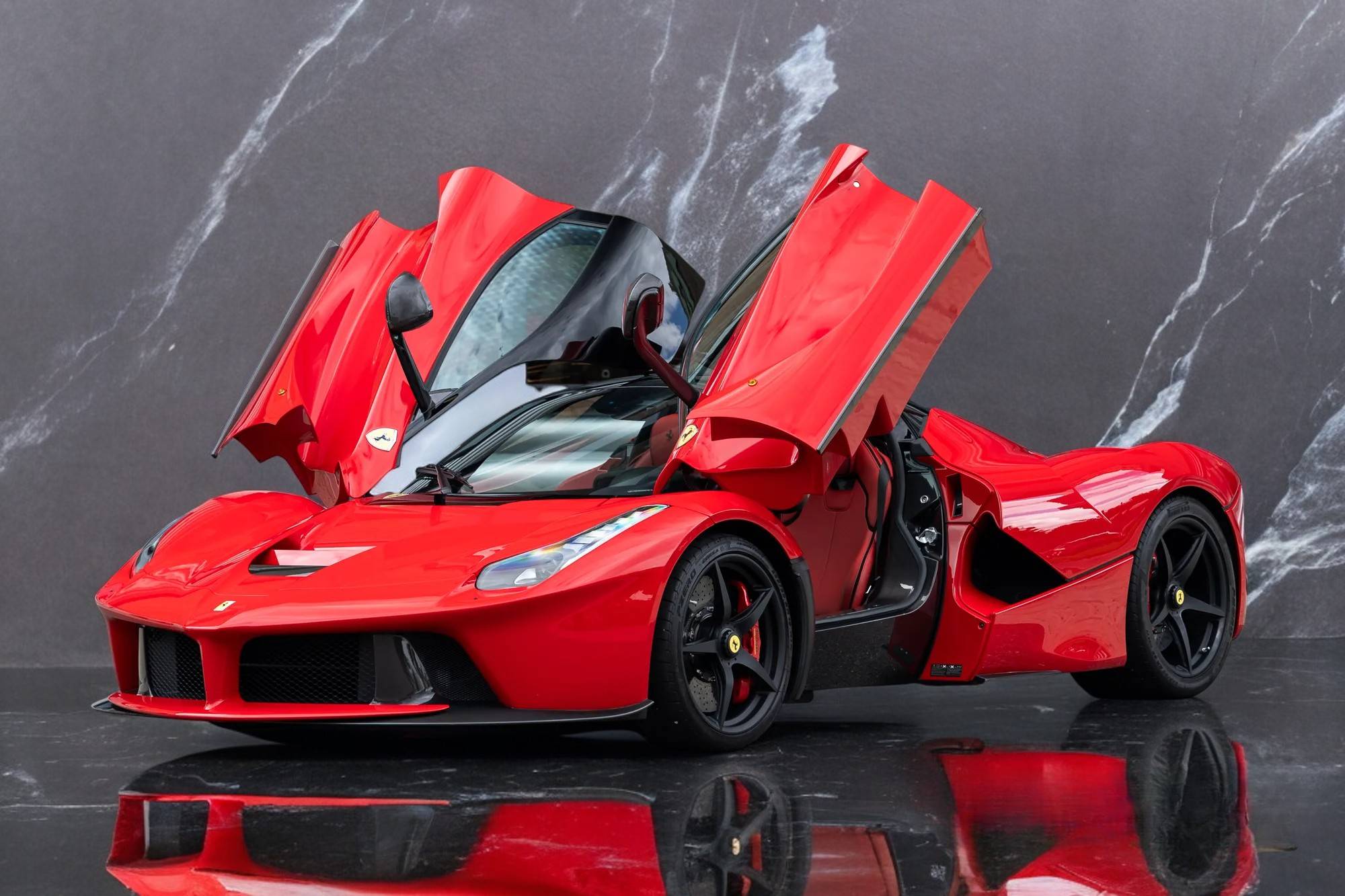 Ferrari LaFerrari parked against marble wall in Ibiza – luxury car rental by King Luxury Ibiza